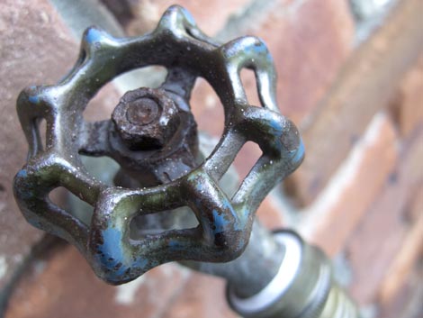 Waterworks hose faucet on brick wall
